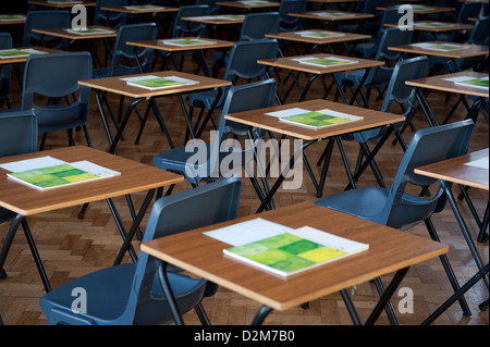 Un bureau et des tables établies pour des examens dans une université britannique gymnase de l'école. Banque D'Images