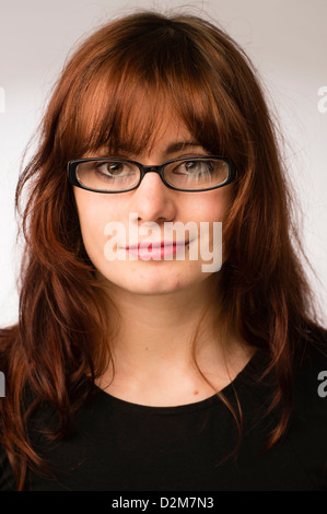 Un dix-neuf ans, fille, jeune femme, avec de longs cheveux bruns, portant des lunettes, UK Banque D'Images