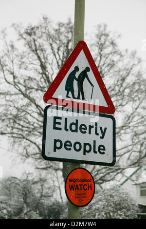 Kinneir & Calvert les personnes âgées attention signe de route et la surveillance de quartier signer en Grande-Bretagne, mauvais temps, la neige tout autour de l'enseigne. Banque D'Images