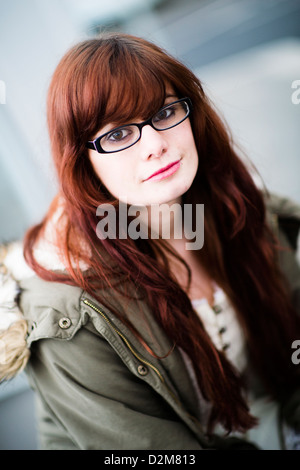 Un dix-neuf ans, fille, jeune femme, avec de longs cheveux bruns, portant des lunettes, UK Banque D'Images