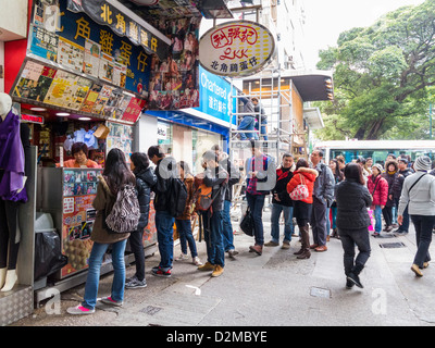 Les gens de la file d'attente en ligne pour Hong Kong Style Egg Waffle street food, Hong Kong Banque D'Images