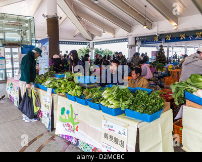 Un étal de légumes biologiques dans un marché, Hong Kong. Banque D'Images