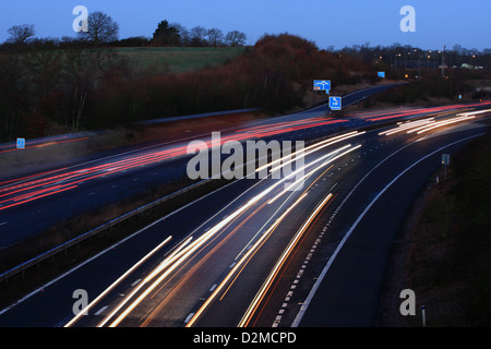 Des sentiers de lumière causé par les véhicules qui circulent sur l'autoroute M20 tôt un matin. Banque D'Images