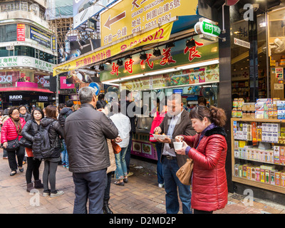 Occupé à bloquer la vente de la célèbre Hong Kong gaufres oeufs Aliments de rue avec des personnes queuing Banque D'Images