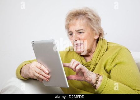 Dame mature à l'aide d'une tablette numérique. Banque D'Images