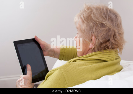 Dame mature à l'aide d'une tablette numérique. Banque D'Images