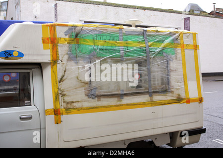 Busted réparé fenêtre sur un très petit camping-van dans les rues de Bristol, Janvier 2013 Banque D'Images