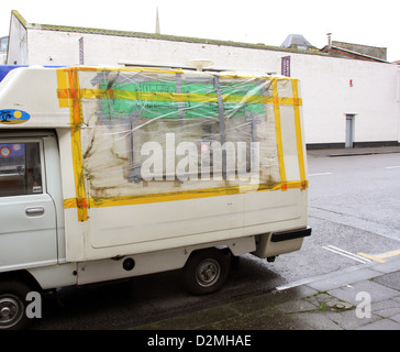 Busted réparé fenêtre sur un très petit camping-van dans les rues de Bristol, Janvier 2013 Banque D'Images