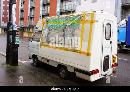 Busted réparé fenêtre sur un très petit camping-van dans les rues de Bristol, Janvier 2013 Banque D'Images