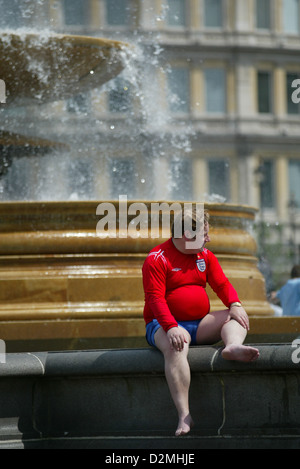 Un grand homme en Angleterre rouge football shirt palettes dans fontaine à Trafalgar Square, Londres, Angleterre, Royaume-Uni, Europe Banque D'Images