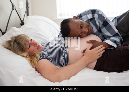 Femmes enceintes et femmes blanc mâle noir à écouter le rythme cardiaque de bébé Banque D'Images