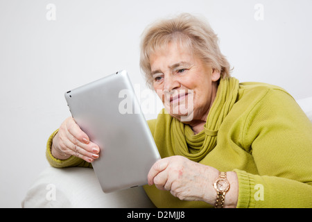 Dame mature à l'aide d'une tablette numérique.