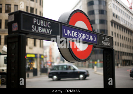 Gros plan d'un panneau de métro londonien à Bank Station, avec un taxi noir traditionnel à l'arrière-plan, dans la ville de Londres, Angleterre, Royaume-Uni Banque D'Images