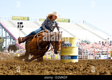 Barrel Racer en compétition au Rodéo de Salinas en Californie, mettant en valeur vitesse et précision à cheval pendant que le coureur navigue sur le parcours Banque D'Images