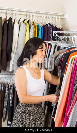 Portrait vertical de mature Asian woman selecting clothes s'habiller dans une penderie Banque D'Images