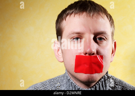 L'homme se ferme sa bouche la paperasserie, creative, symbolisant la lutte pour la liberté d'expression et contre la censure Banque D'Images