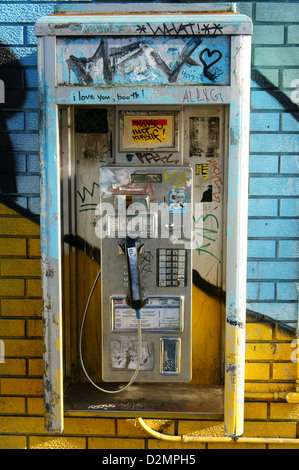 Vieux téléphone payant à pièces sur un mur coloré, Main Street, Vancouver, BC, Canada Banque D'Images