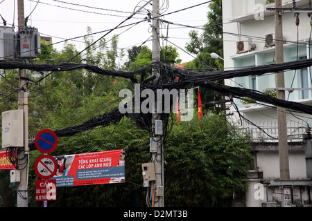 C'est une photo de fils électriques tous mélangés et collées sur un pylône . C'est dans une rue de Saigon au Vietnam. Nous voir Road sign Banque D'Images