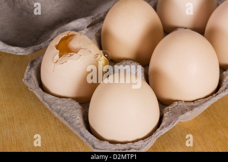 Oeuf cassé dans un carton avec d'autres oeufs Banque D'Images