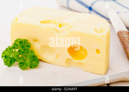 Morceau de fromage Edam bio frais sur planche de bois sur la table de cuisine petit déjeuner Banque D'Images
