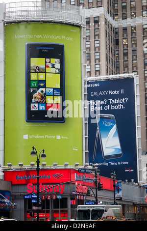 La publicité pour le logiciel d'exploitation Microsoft Windows 8 en face d'un panneau pour le Samsung Note II téléphone à l'aide d'Android Banque D'Images