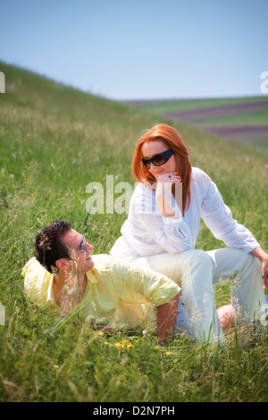 Image conceptuelle avec femme assise sur l'homme, portrait en extérieur. Banque D'Images