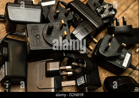 Une pile de vieux chargeurs de téléphones redondants et d'autres adaptateurs d'alimentation électrique UK Banque D'Images