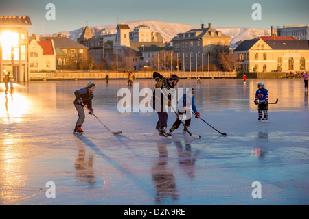 Jouer au hockey sur glace sur l'étang de Reykjavik, en Islande. Tjornin est le nom islandais pour l'étang. Banque D'Images
