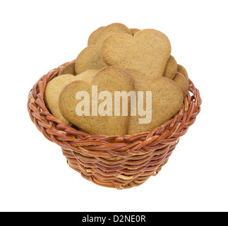 Un vieux panier en osier rempli de ginger cookies snap sur un fond blanc. Banque D'Images