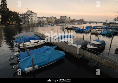 Bateaux sur la rivière Limmat au crépuscule. Zurich, Suisse. Banque D'Images