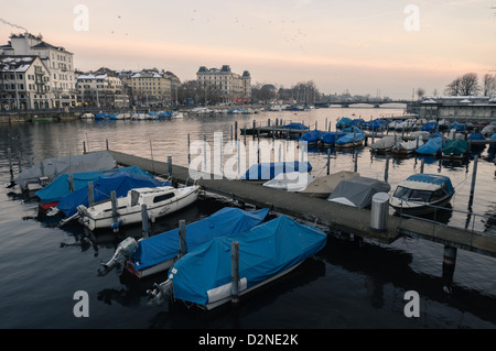 Bateaux sur la rivière Limmat au crépuscule. Zurich, Suisse. Banque D'Images