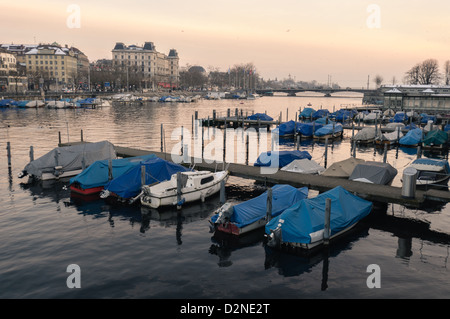 Bateaux sur la rivière Limmat au crépuscule. Zurich, Suisse. Banque D'Images