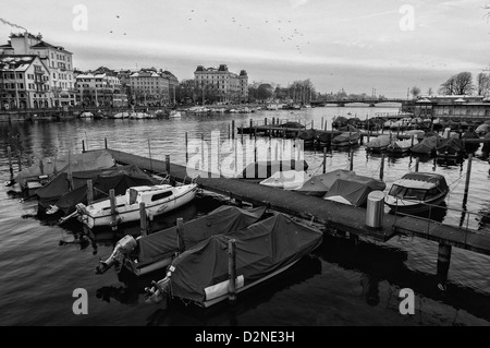 Bateaux sur la rivière Limmat au crépuscule. Zurich, Suisse. Banque D'Images