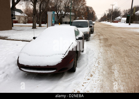 Recouvert de neige voiture garée sur la rue de Pleasant Hill Saskatoon Saskatchewan Canada Banque D'Images