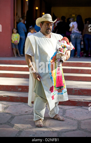 Homme en tenue traditionnelle tenant son bébé fils lors de la célébration de l’anniversaire de la Virgen de Guadalupe au Mexique Banque D'Images