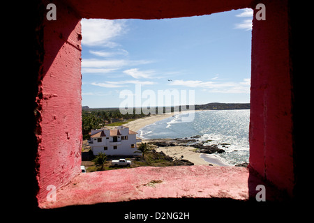 Une vue imprenable sur la côte encadrée par la fenêtre rose vibrante d'un phare à Mazatlán, Sinaloa, Mexique. Banque D'Images