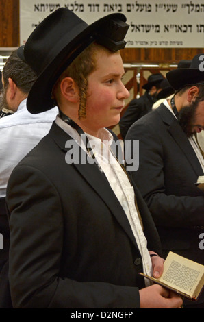 Au siège de Loubavitch à Brooklyn, NY un jeune garçon portant des phylactères dit la prière du matin. Banque D'Images