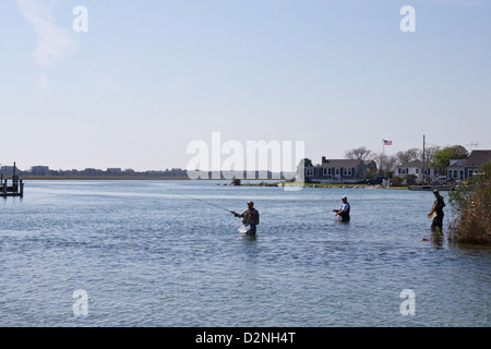 Pêcheurs à la ligne paternant dans la baie de Narragansett, en profitant de la pêche en eau salée dans le cadre pittoresque des charmantes maisons riveraines de la Nouvelle-Angleterre. Banque D'Images