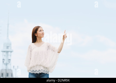 Jeune femme en pointant un doigt Banque D'Images
