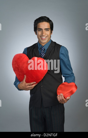 Portrait of a businessman holding a coussin et une boîte-cadeau Banque D'Images