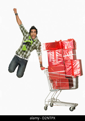 L'homme appuyé contre un panier rempli de cadeaux cheering Banque D'Images