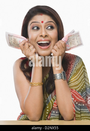 Close-up of a woman holding roupie indienne mille rire et notes Banque D'Images