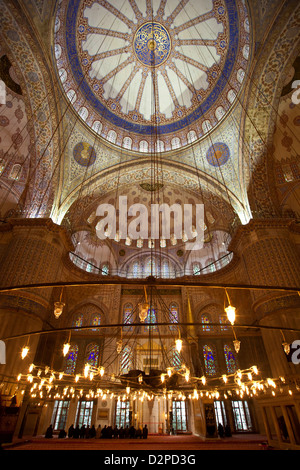 Turquie ISTANBUL - Mosquée bleue Sultan Ahmet Camii ( ) Vue de l'intérieur avec les hommes musulmans prier par les fenêtres en verre - Sultanahmet Banque D'Images