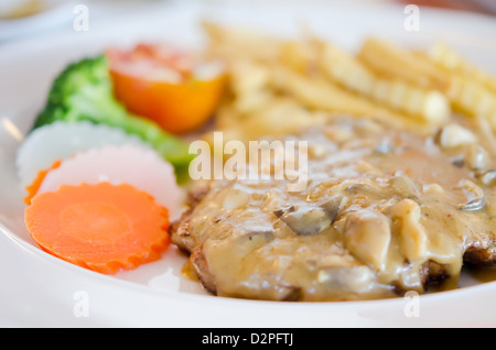 Pavé de boeuf avec sauce aux champignons et de légumes sur la plaque Banque D'Images