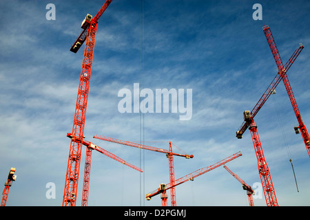 Berlin, Allemagne, les grues de construction rouge contre le ciel bleu Banque D'Images