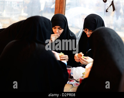 Femme turque musulmane traditionnelle bénéficiant d'un sandwich de poisson par le pont de Galata à Istanbul. Banque D'Images