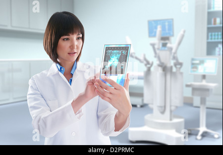 Mixed Race doctor looking at digital tablet in doctor's office Banque D'Images