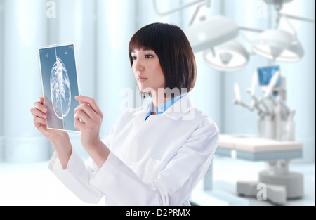Mixed Race doctor looking at digital tablet in operating room Banque D'Images