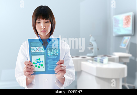 Mixed Race doctor using digital tablet in laboratory Banque D'Images