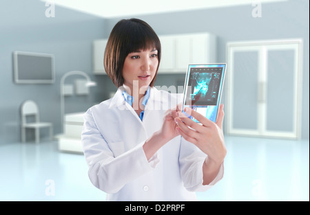 Mixed Race doctor using digital tablet in doctor's office Banque D'Images